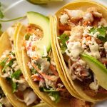 Tacos de pollo desmenuzado con guacamole ligero y cebolla morada